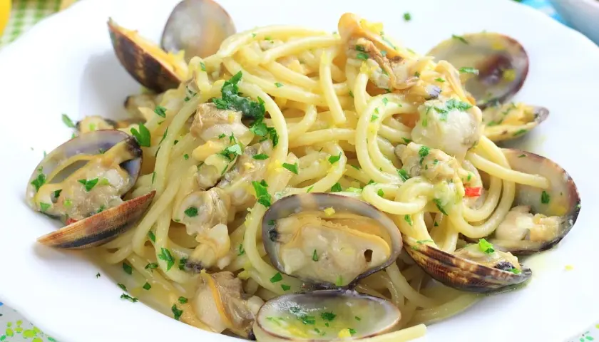 Un piatto invitante di linguine alle vongole, condite con prezzemolo fresco e un filo d'olio.
