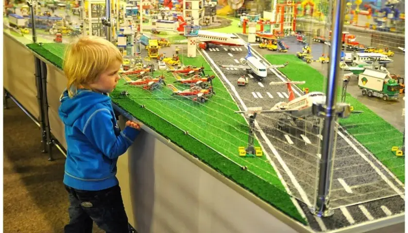 Chłopiec zafascynowany lotniskiem z klocków LEGO w Muzeum Klocków LEGO Kraków.