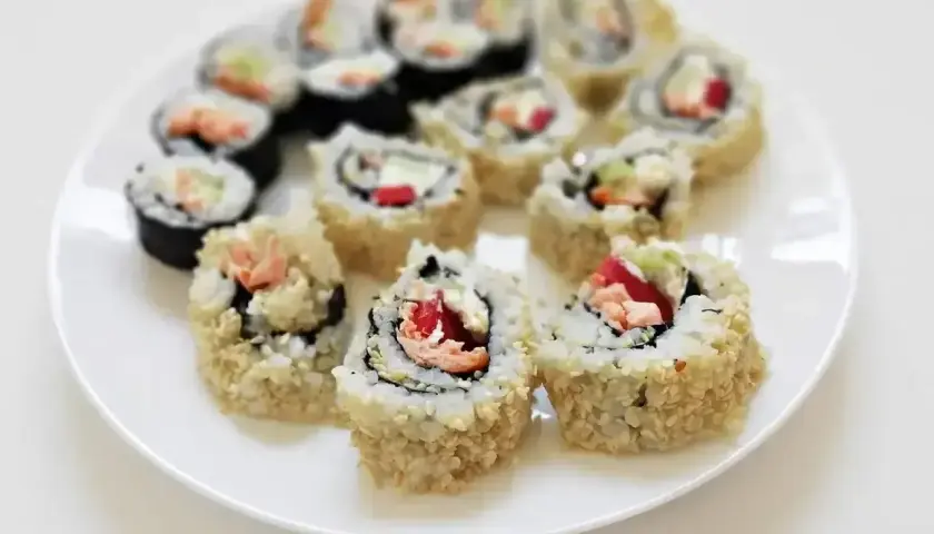 Talerz pełen pysznego california sushi, z łososiem, awokado i sezamem. Idealne na lekki posiłek.