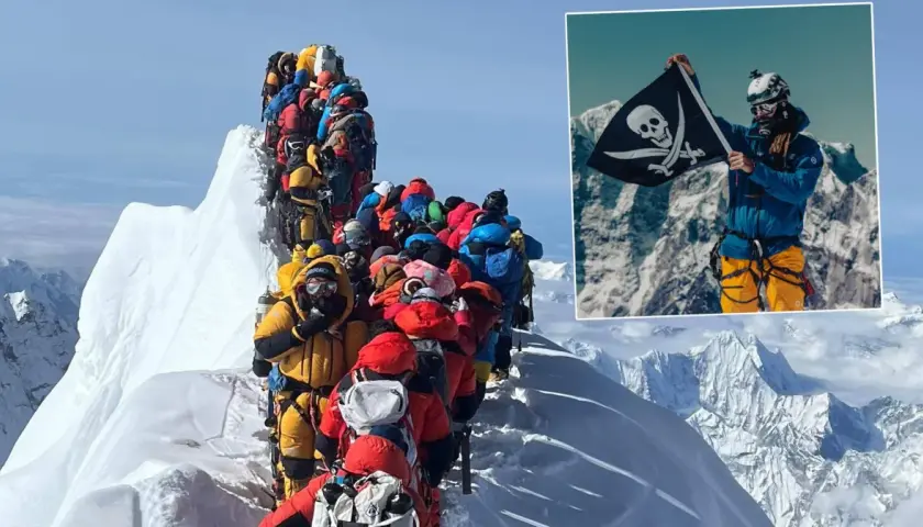 Kolejka wspinaczy na szczycie Everestu. W rogu pirat z flagą, wszystko za Everest.