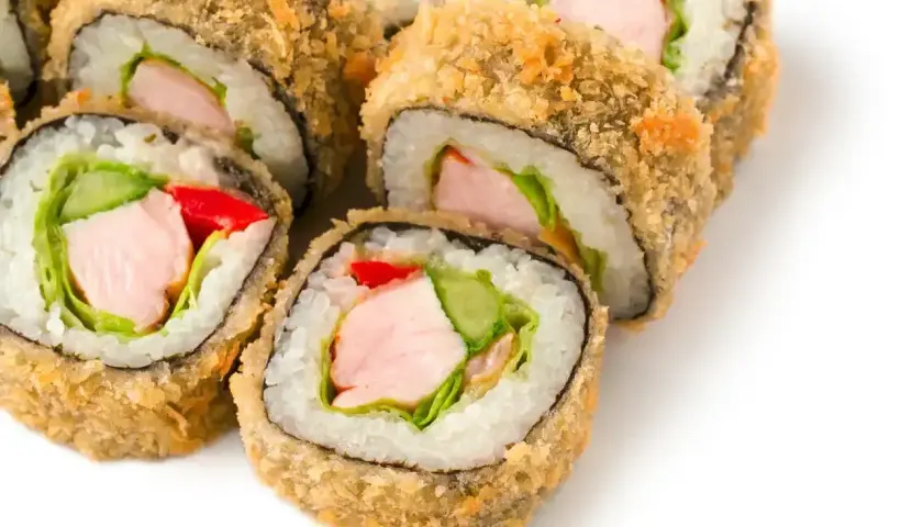 Chrupiące rolki sushi z kurczakiem, ogórkiem, papryką i sałatą, obtoczone w panko.