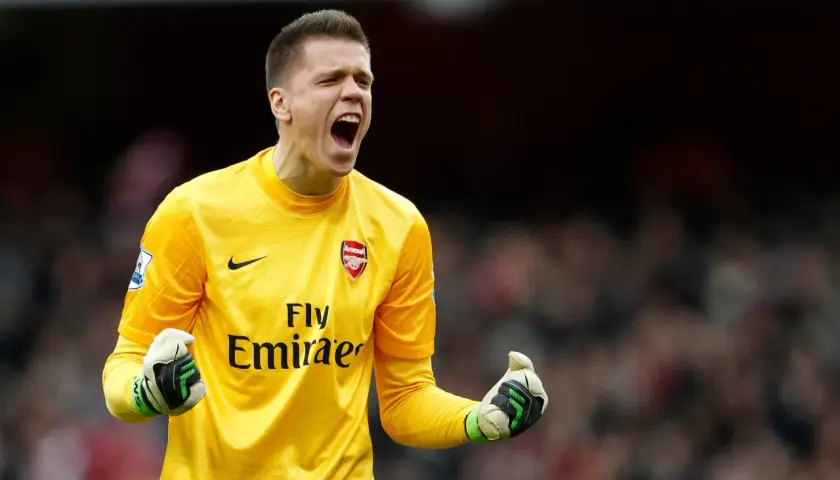 Wojciech Szczęsny w żółtej koszulce Arsenalu, krzyczy z radości. Grał też w Romie i Juventusie.