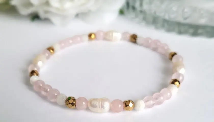 Delikatna bransoletka z koralików kwarc różowy, pereł i złotych elementów. Symbol miłości i harmonii.