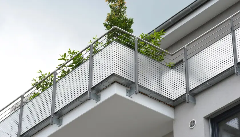 Nowoczesny balkon z ażurową balustradą i zielenią. Solidna hydroizolacja balkonu zapewnia trwałość i komfort użytkowania.