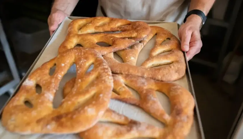 Une fougasse aux grattons feuilletée, dorée et croustillante, sort du four. Un délice à partager !