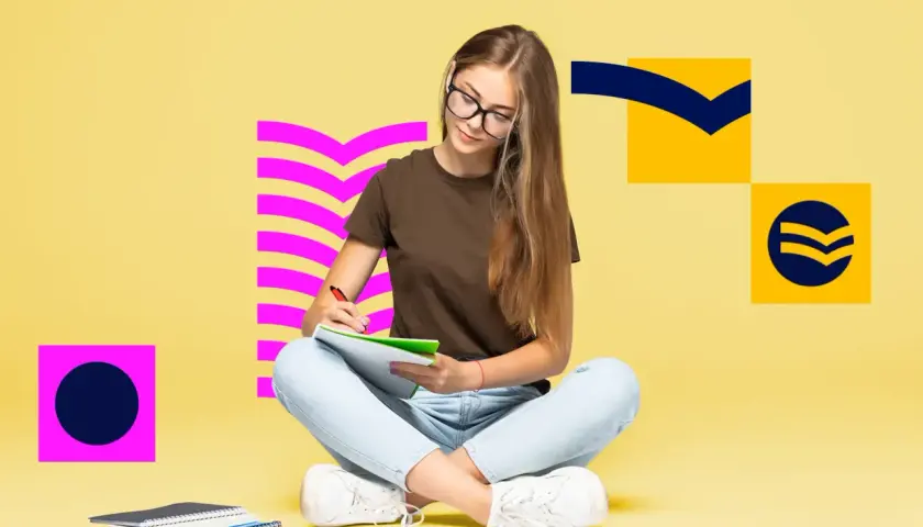 Dziewczyna pisze w zeszycie, przygotowując się do matury z angielskiego. Szuka inspiracji i przykładów wypowiedzi pisemnych.