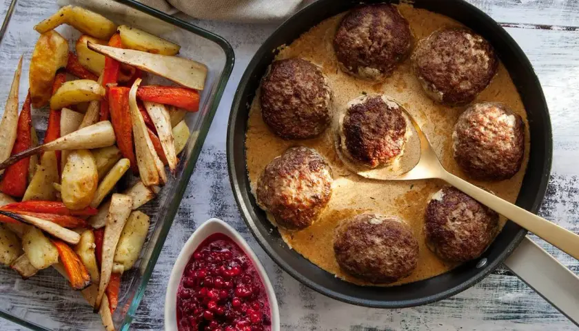Biffar i ugn i krämig sås, serverade med ugnsrostade rotfrukter och rårörda lingon. En klassisk svensk middag.