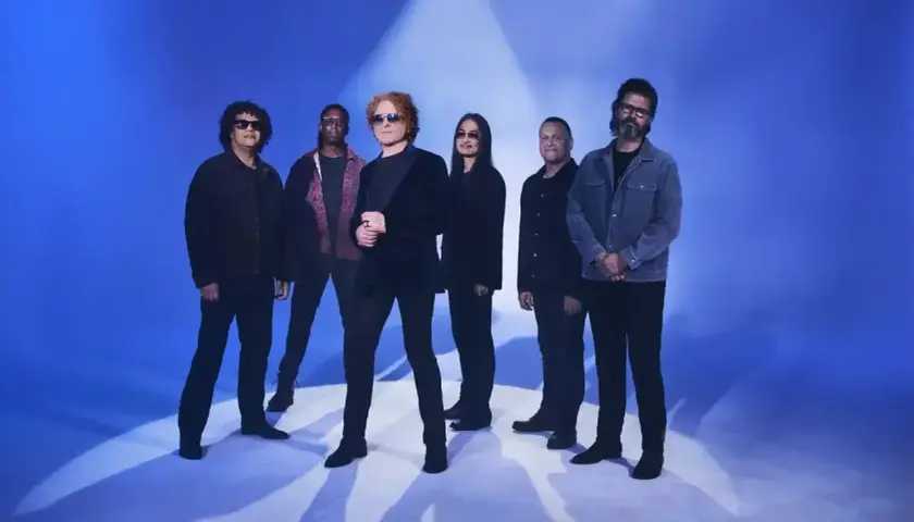 Zespół Simply Red na niebieskim tle, gotowy do koncertu.