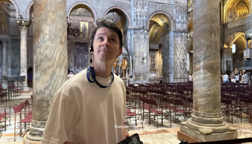 Un homme admire la splendeur de la basilique Saint-Marc, ses yeux levés vers les mosaïques dorées et les colonnes imposantes.