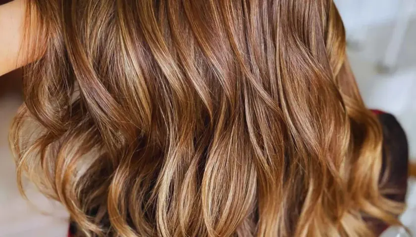 Ondas suaves y brillantes con reflejos en pelo castaño, como si el sol jugara entre los mechones.
