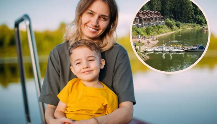 Uśmiechnięta mama z synkiem na pomoście. W tle jezioro z łódkami i domkami, idealne na wakacje z bonem turystycznym 2026.