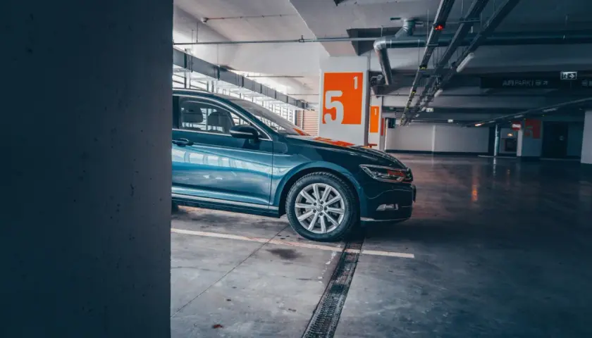Auto blu parcheggiata nel parcheggio della metro Cipro, con numeri arancioni sulle colonne.