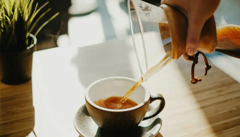 Parzona kawa przelewana z Chemexu do filiżanki. Zastanawiasz się, ile kofeiny ma latte?