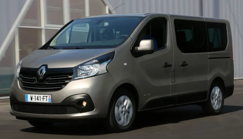 Szary Renault Trafic 3 w ruchu, z widocznym kierowcą za kierownicą.