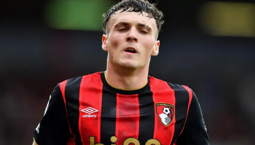 Piłkarz AFC Bournemouth w czerwono-czarnej koszulce, gotowy na kolejne bournemouth transfery.