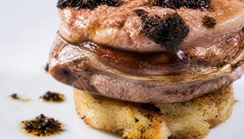 Tournedos Rossini, un délice avec foie gras et truffes. Quel vin avec tournedos rossini ? Un vin rouge corsé comme un Bordeaux ou un Bourgogne.