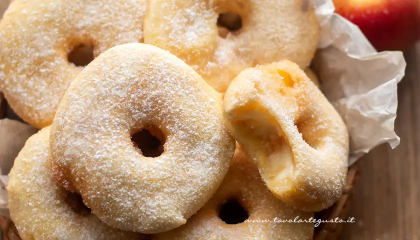 Frittelle di mele della nonna, dorate e cosparse di zucchero a velo, invitano a un morso goloso.