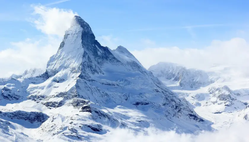 Majestatyczny szczyt Matterhorn, korona Europy, w otoczeniu innych ośnieżonych gór.