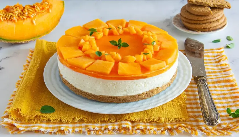 Deliziosa cheesecake al melone, con strati cremosi e topping fresco di melone a cubetti e gelatina. Perfetta per l'estate!