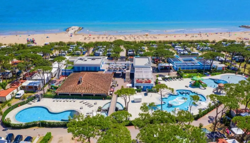 Vue aérienne d'un camping et d'une plage à Cavallino, Italie. Piscines, mobil-homes et mer bleue.