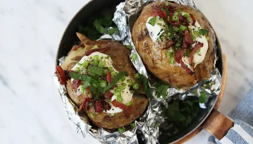 Två bakade potatisar med krämig fyllning, knaprigt bacon och färska örter. En härlig bakad potatis fyllning som ser utsökt ut.