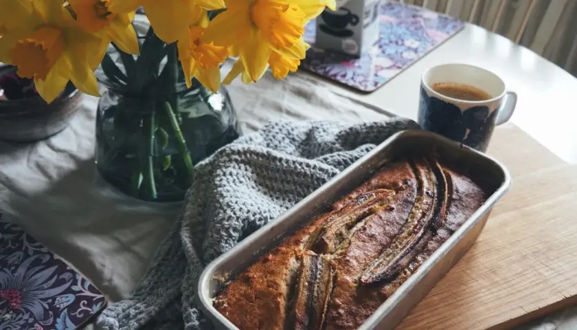 Nybakad banankaka, kanske från Sofia Wood, med kaffe och påskliljor. En mysig fika.