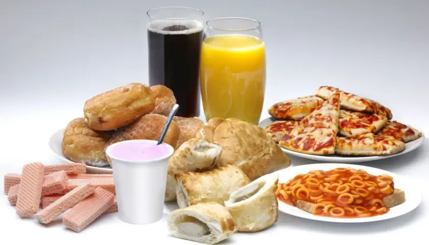 Słodkie bułeczki, pizza, słodkie napoje i inne przykłady żywności wysoko przetworzonej.
