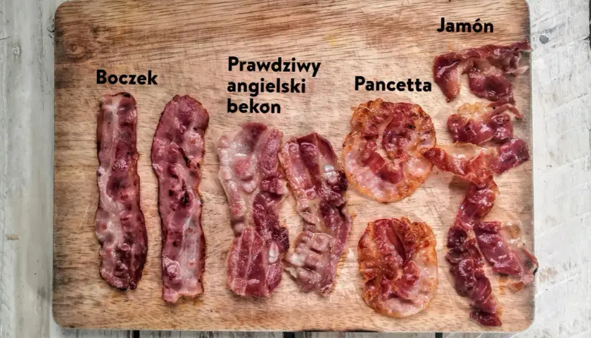 Różne rodzaje boczku: polski, angielski, pancetta i jamón, ułożone na desce.