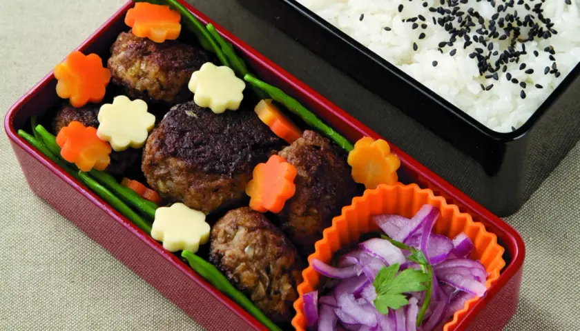 Hamburger bento with meatballs, star-shaped carrots, cheese, green beans, and pickled red onions.