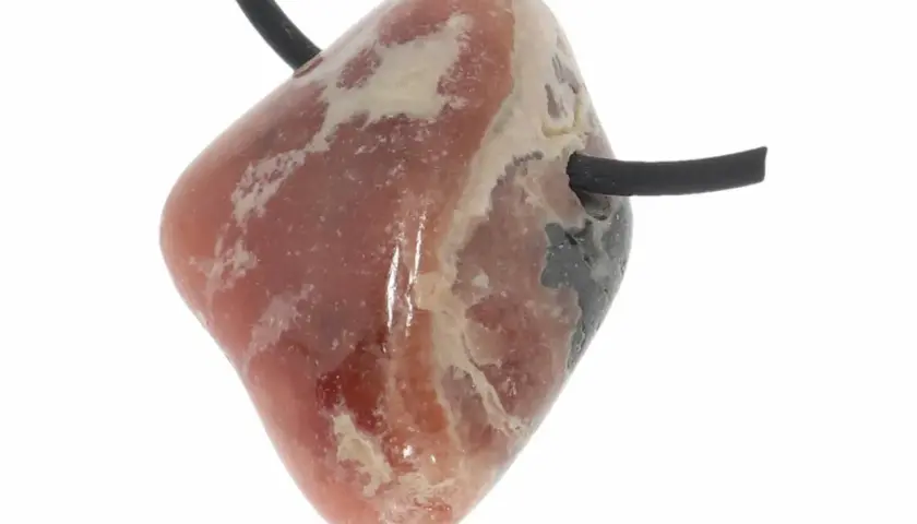Ein facettierter Rhodochrosit-Anhänger mit schwarzem Band. Seine rosa Farbe und die hellen Einschlüsse deuten auf seine positive Rhodochrosit Wirkung hin.