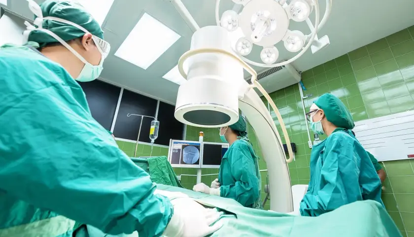 Chirurghi in sala operatoria, concentrati sul loro lavoro. La loro **responsabilità professionale** è evidente in ogni gesto.
