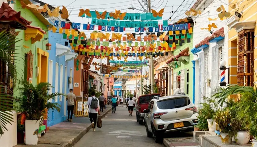 Bunte Häuser und Schmetterlingsgirlanden säumen eine Straße. Perfekt für die beste Reisezeit Curacao, um diese lebendige Atmosphäre zu genießen.