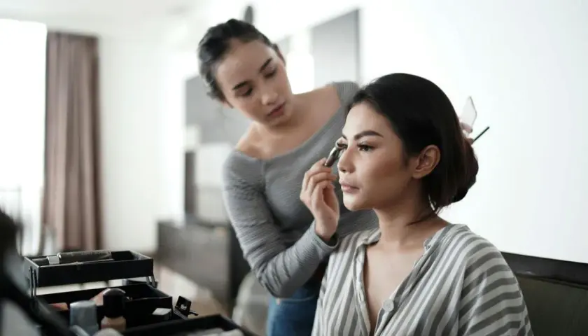 En makeupartist applicerar en silikonbaserad primer på en kvinna.