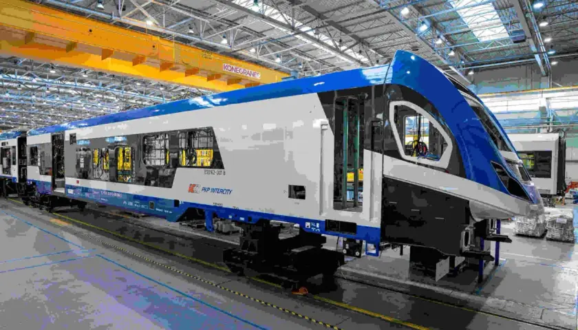 Nowe, niebiesko-białe zespoły trakcyjne PKP Intercity w hali produkcyjnej.