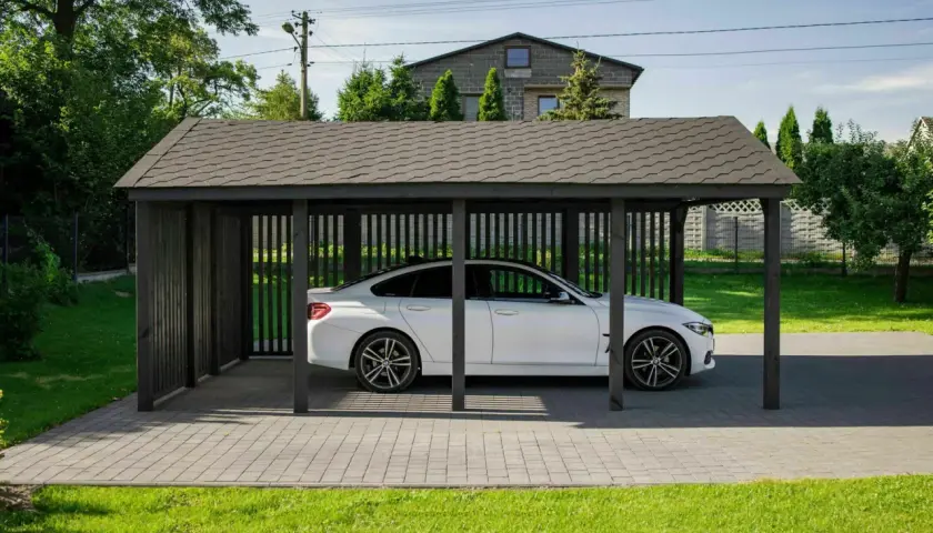 Nowa wiata bez pozwolenia wymiary idealnie pasuje do białego BMW. Solidna konstrukcja chroni auto przed słońcem i deszczem.