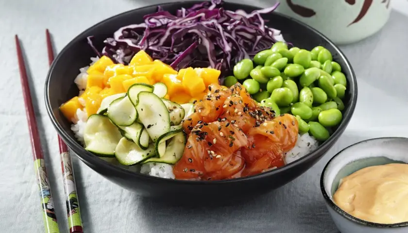 En färgglad poke bowl med lax, mango, gurka, edamamebönor och rödkål. En perfekt och hälsosam måltid.