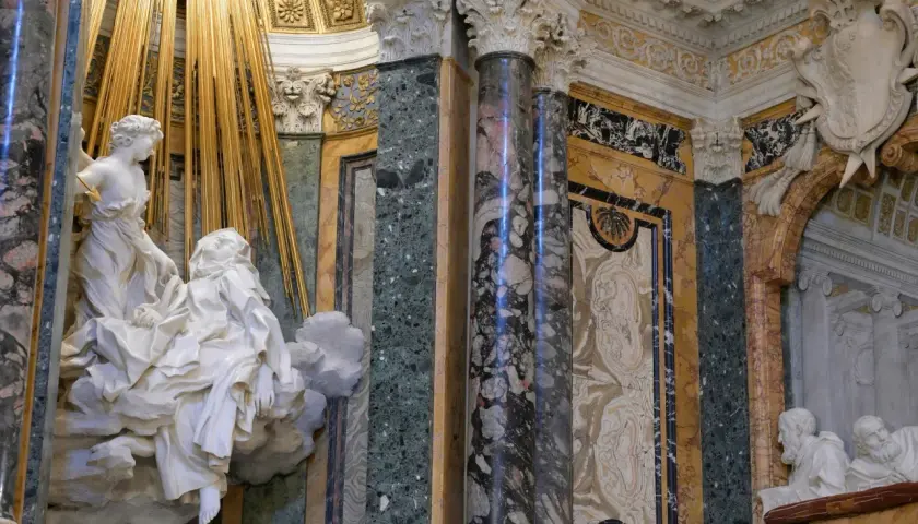La Cappella Cornaro: un angelo colpisce Santa Teresa con una freccia dorata, circondata da marmi preziosi e decorazioni barocche.
