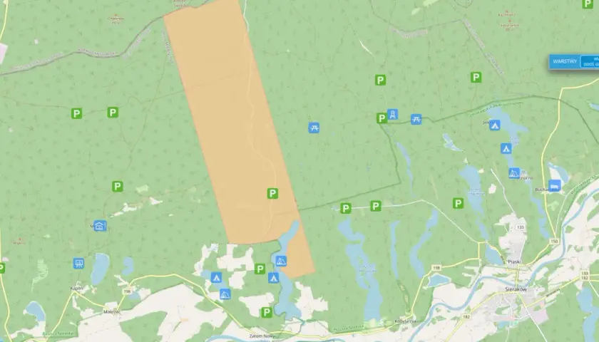 Mapa z zaznaczonymi darmowymi miejscami biwakowymi w lesie, obok jezior i dróg.