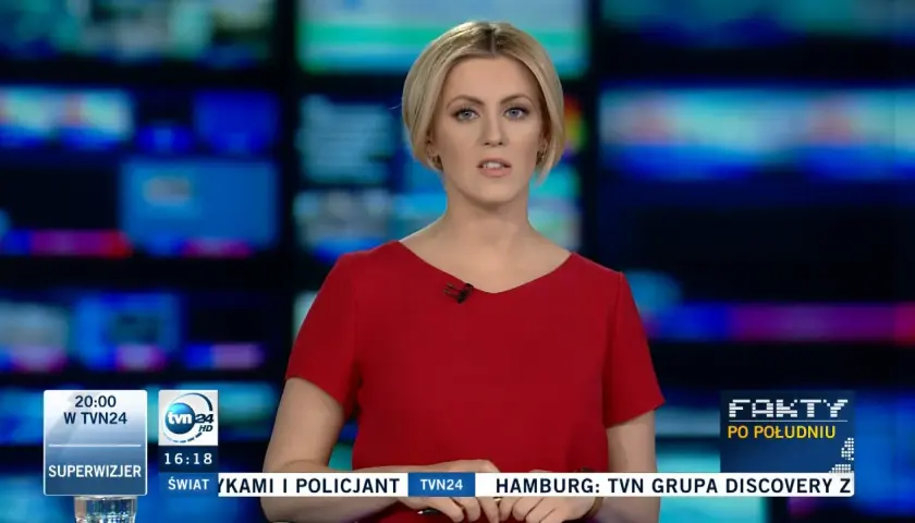 Justyna Kosela, prezenterka w czerwonej sukience, na tle ekranów. Ile ma lat? Tego nie wiemy, ale wygląda profesjonalnie.