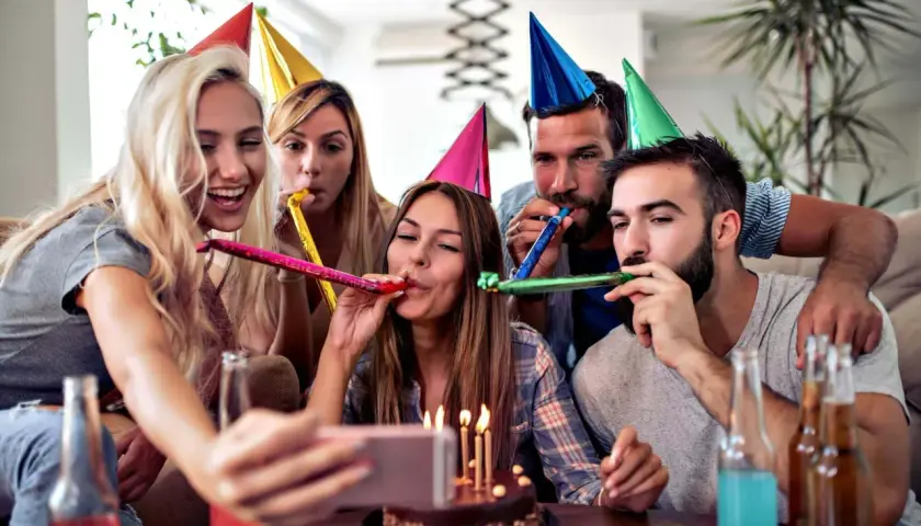 Grupa przyjaciół świętuje urodziny, dmie w trąbki i robi selfie. Idealny pomysł, jak zorganizować 70 urodziny na wesoło!