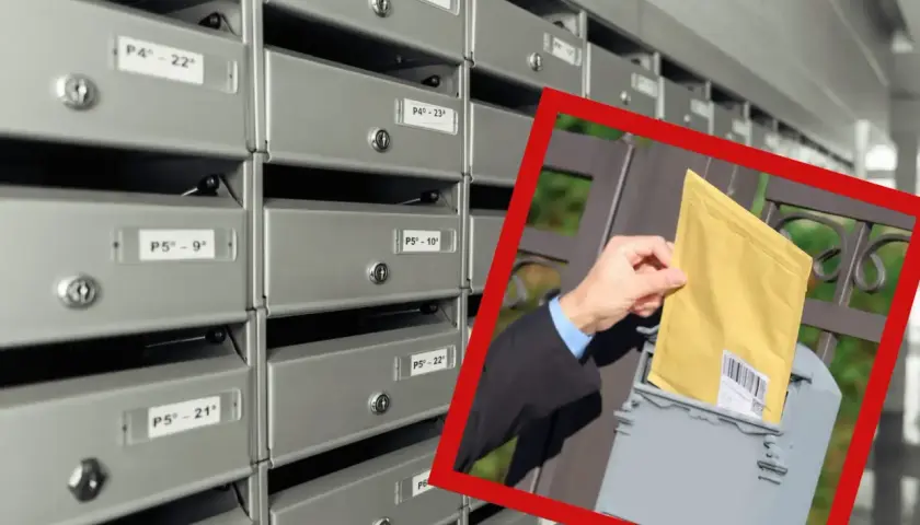 Awizo przesyłka polecona co to może być? Dłoń wkłada żółtą kopertę do skrzynki pocztowej obok rzędu skrytek.