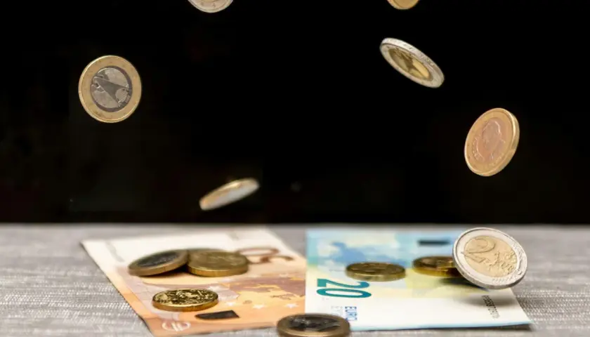 Monety euro spadają na banknoty 50 i 20 euro. To symboliczna scena pokazująca portugalia waluta w ruchu.