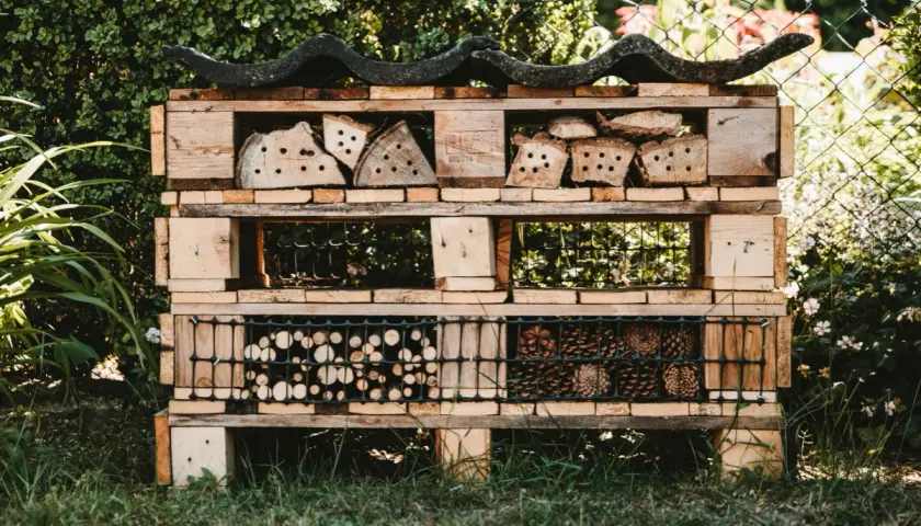 Domek dla owadów z palet, pełen naturalnych materiałów. Świetne upcycling przykłady dla ogrodu.