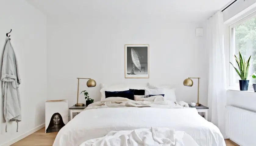 Ett ljust och luftigt sovrum med stor säng, konst och växter. En känsla av lugn och harmoni som passar bra för feng shui sovrum.