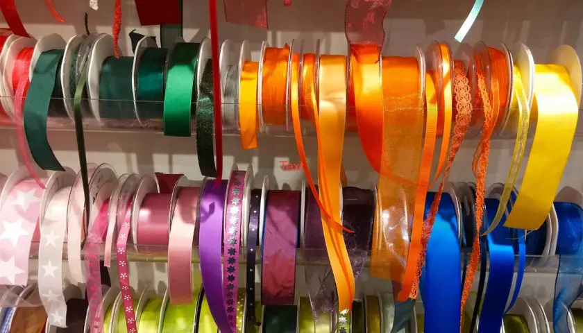 Rouleaux de rubans colorés, de différentes textures et motifs. Ces rubans servent à décorer, emballer, et à ajouter une touche de fantaisie aux vêtements.