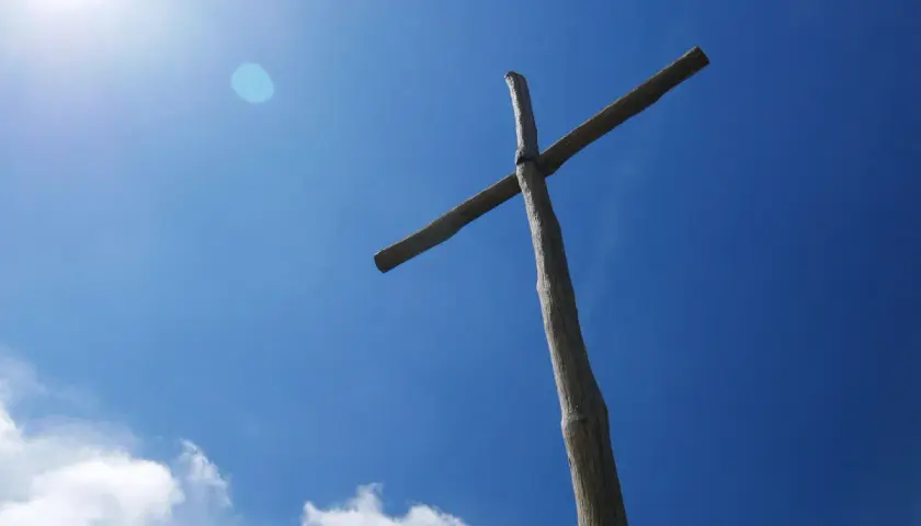 Drewniany krzyż na tle błękitnego nieba. Czy prawosławie to chrześcijaństwo? Symbol wiary.