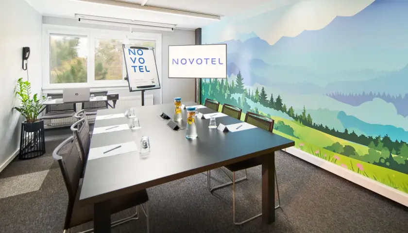 Nowoczesna sala konferencyjna Novotel z malowniczą wizualizacją dla dorosłych na ścianie.