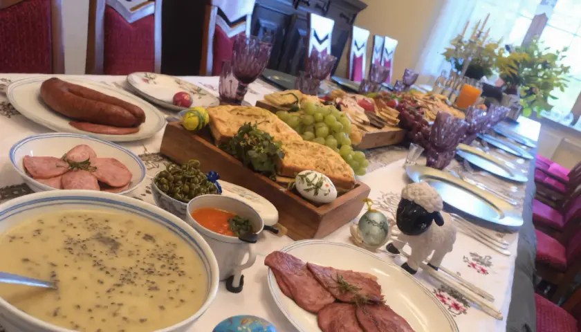 Uczta w gazdówce: bieszczadzkie smaki, kiełbasa, zupa, wędliny, winogrona i wielkanocne pisanki.