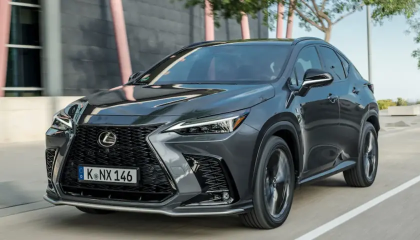Elegancki, ciemnoszary Lexus NX 350h w ruchu ulicznym, z charakterystycznym grillem i ostrymi światłami.