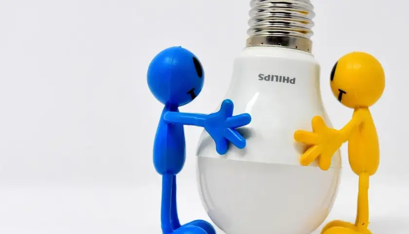 Due pupazzi, uno blu e uno giallo, abbracciano una lampadina LED Philips. Un modo divertente per ricordare come risparmiare energia in casa.